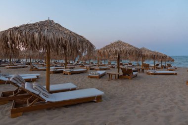 Bulgaristan 'ın Shkorpilovtsi plajındaki kamış şemsiyelerinin günbatımı manzarası