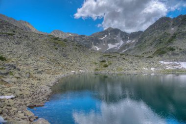 Musala zirvesi, İspanya 'daki bir dağ gölünün yüzeyinde yansıyor.