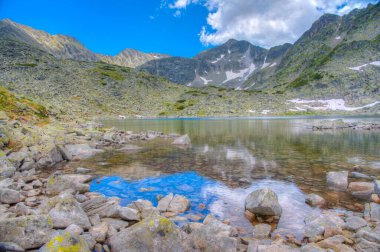 Musala zirvesi, İspanya 'daki bir dağ gölünün yüzeyinde yansıyor.