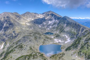 Musala zirvesi, İspanya 'daki bir dağ gölünün yüzeyinde yansıyor.
