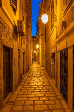 Hırvatistan 'ın eski Sibenik kentinde eski dar bir caddenin gece manzarası