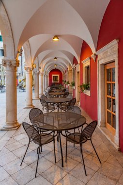 Hırvatistan 'ın eski Sibenik kentindeki bir atari salonunda restoran masaları