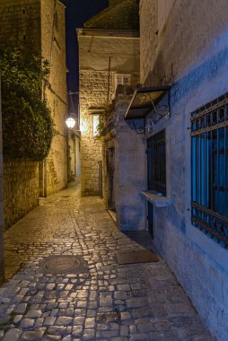 Hırvatistan 'ın Trogir kentindeki eski dar bir caddenin gece manzarası