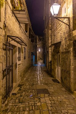 Hırvatistan 'ın Trogir kentindeki eski dar bir caddenin gece manzarası