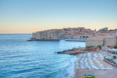 Hırvatistan 'da bir plajın arkasındaki Dubrovnik' in gündoğumu manzarası