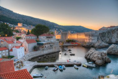 Hırvatistan 'ın Dubrovnik kentindeki eski kent tahkimatı önündeki küçük bir körfezin gün doğumu manzarası