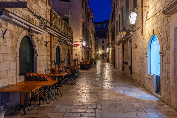 Hırvatistan 'ın eski Dubrovnik kentinde dar bir sokakta restoran masalarının gündoğumu manzarası