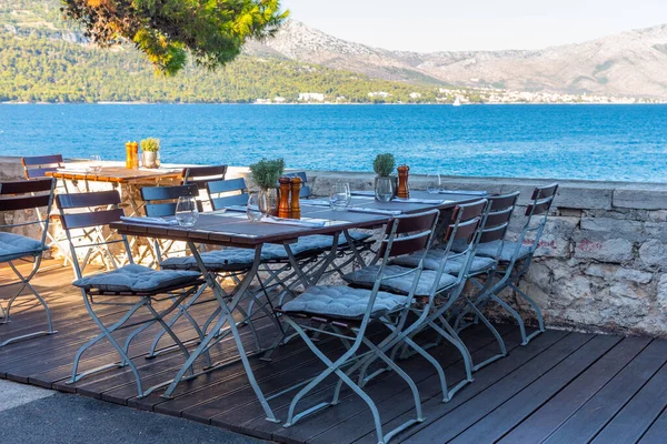 Hırvatistan 'ın eski Korcula kentindeki sahil yürüyüşündeki sandalye ve masalar