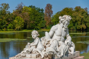 Güneşli yaz gününde Almanya 'daki Schwetzingen Sarayı' ndaki su kanalında heykel