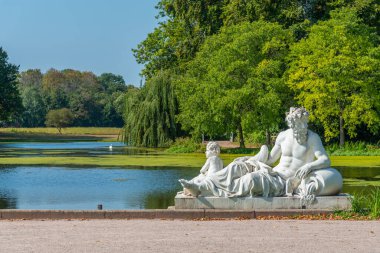 Güneşli yaz gününde Almanya 'daki Schwetzingen Sarayı' ndaki su kanalında heykel