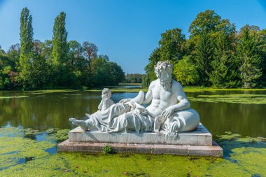 Güneşli yaz gününde Almanya 'daki Schwetzingen Sarayı' ndaki su kanalında heykel