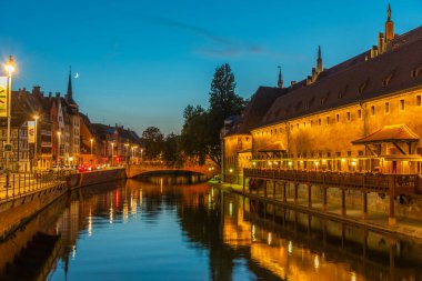 Strasbourg, Fransa 'da Antik çağlardan kalma Douanne binasından geçen bir kanalın gün batımı manzarası