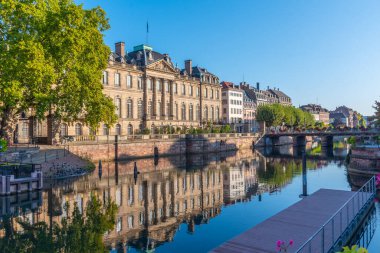 Palais Rohan 'ın gün doğumu manzarası Strazburg, Fransa' daki suya yansıyor