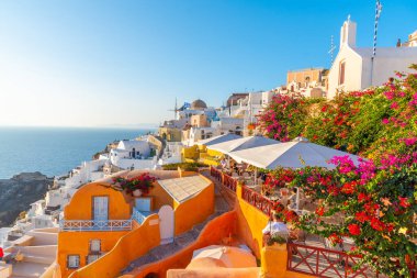 Yunanistan 'ın Santorini adasındaki Oia köyü üzerinde gün batımı manzarası