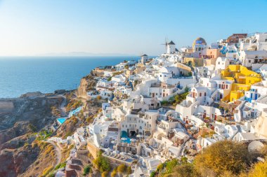 Yunanistan 'ın Santorini adasındaki Oia köyü üzerinde gün batımı manzarası