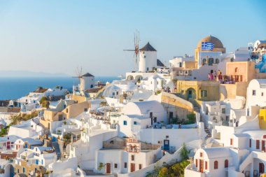 Yunanistan 'ın Santorini adasındaki Oia köyü üzerinde gün batımı manzarası