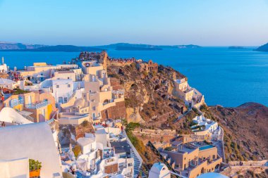 Yunanistan 'ın Santorini adasında Oia şatosuyla günbatımı manzarası