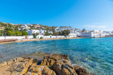 İnsanlar Yunanistan 'ın Mykonos plajında güneşli bir günün tadını çıkarıyorlar