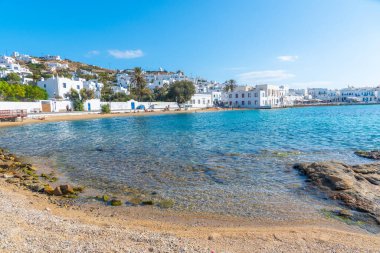 İnsanlar Yunanistan 'ın Mykonos plajında güneşli bir günün tadını çıkarıyorlar