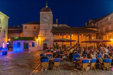 Trogir, Hırvatistan, 22 Temmuz 2020: Hırvatistan 'ın Trogir kentindeki Ivana Pavla II meydanında insanlar akşam yemeği yiyor