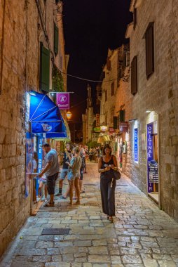 Trogir, Hırvatistan, 22 Temmuz 2020: İnsanlar, Hırvatistan 'ın Trogir kentindeki eski dar bir sokakta gece boyunca dolaştılar