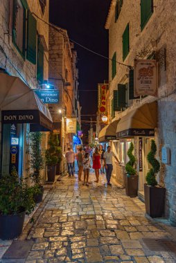 Trogir, Hırvatistan, 22 Temmuz 2020: İnsanlar, Hırvatistan 'ın Trogir kentindeki eski dar bir sokakta gece boyunca dolaştılar