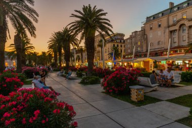 Split, Hırvatistan, 29 Temmuz 2020: Hırvatistan 'ın Split kentinde deniz kenarında yürüyen insanların gece görüşü