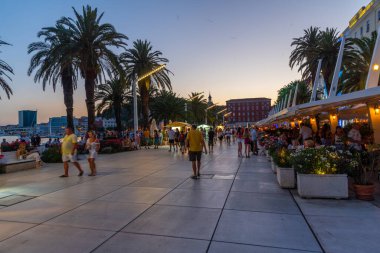 Split, Hırvatistan, 29 Temmuz 2020: Hırvatistan 'ın Split kentinde deniz kenarında yürüyen insanların gece görüşü