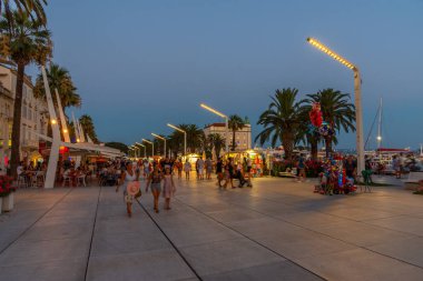 Split, Hırvatistan, 29 Temmuz 2020: Hırvatistan 'ın Split kentinde deniz kenarında yürüyen insanların gece görüşü