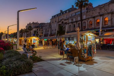 Split, Hırvatistan, 29 Temmuz 2020: Hırvatistan 'ın Split kentinde deniz kenarında yürüyen insanların gece görüşü