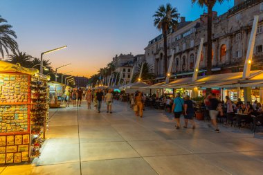 Split, Hırvatistan, 29 Temmuz 2020: Hırvatistan 'ın Split kentinde deniz kenarında yürüyen insanların gece görüşü