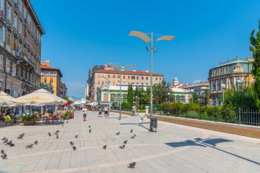 Rijeka, Hırvatistan, 30 Temmuz 2020: İnsanlar Hırvatistan 'ın Rijeka kentindeki tiyatro parkının önünden geçen bir sokakta geziniyorlar