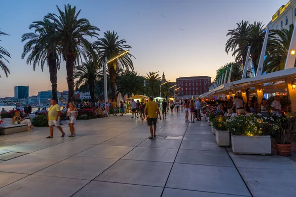 Split, Hırvatistan, 29 Temmuz 2020: Hırvatistan 'ın Split kentinde deniz kenarında yürüyen insanların gece görüşü