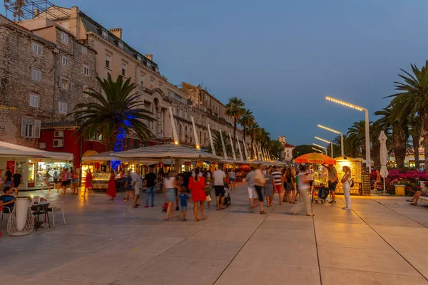 Split, Hırvatistan, 29 Temmuz 2020: Hırvatistan 'ın Split kentinde deniz kenarında yürüyen insanların gece görüşü