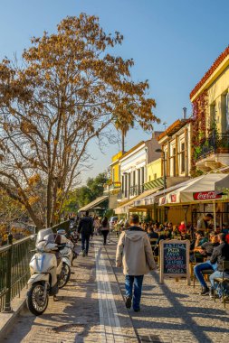 ATHENS, GREECE, DECEMBER 10, 2015: tourists are walking through a narrow alley between agora complex and many restaurants