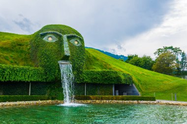 WATTENS, AUSTRIA, JULY 27, 2016: Fountain with giant head spitting water into a pond at swarovski Kristallwelten in Wattens, Austria.