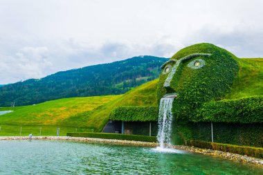 WATTENS, AUSTRIA, JULY 27, 2016: Fountain with giant head spitting water into a pond at swarovski Kristallwelten in Wattens, Austria.