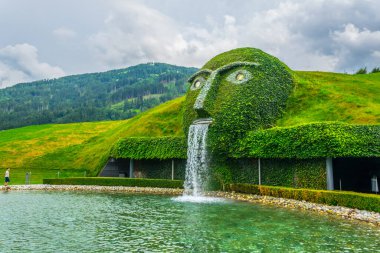 WATTENS, AUSTRIA, JULY 27, 2016: Fountain with giant head spitting water into a pond at swarovski Kristallwelten in Wattens, Austria.
