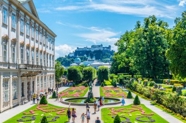 SALZBURG, AUSTRIA, 30 Temmuz 2016: İnsanlar Salzburg, Avusturya 'daki tarihi Hohensalzburg Kalesi' nin arka planında Mirabell Bahçeleri 'nde geziniyorlar