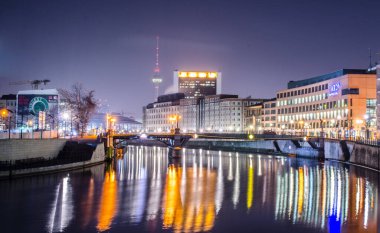 BERLİN, GERMANY, 12 Mart 2015: Berlin ufuk çizgisinin gece görüntüsü Seri nehir yüzeyine yansıyor.
