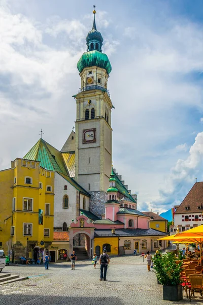 TİRAN, AUSTRIA, 27 HAZİRAN 2016: İnsanlar Avusturya 'nın Tirol kentindeki Hall' da bulunan Aziz Nikolaus Kilisesi 'nin önündeki ana meydanda dolaşıyorlar..