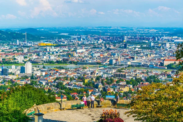 LINZ, AUSTRIA, 30 Temmuz 2016: İnsanlar Avusturya şehri Linz 'in postlingberg tepesinden hava manzarasının keyfini çıkarıyorlar.