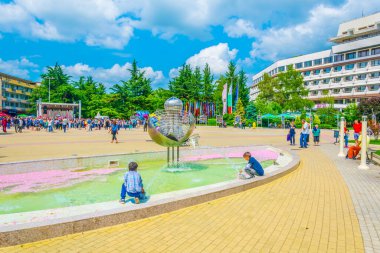 KAZANLAK, BULGARIA, 4 Haziran 2017: Bulgaristan 'ın Kazanlak kentinde düzenlenen ünlü gül festivali sırasında insanlar gül yapraklarıyla kaplı bir çeşmenin yanında oturuyorlar
