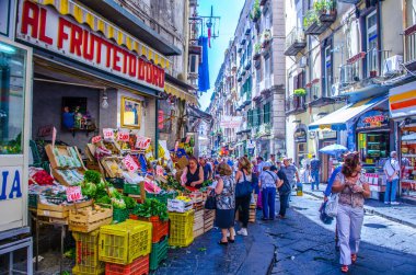 NAPLES, ITALY, HAZİRAN 24, 2014: İnsanlar İtalya Napoli 'deki tarihi eski şehrin dar sokaklarından geçiyor.