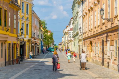 GYOR, HUNGARY 20 Mayıs 2016: Macaristan 'ın eski kentinde insanlar dar bir sokakta yürüyorlar.