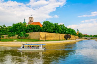 GYOR, HUNGARY 20 Mayıs 2016: Macaristan 'ın Gyor şehrindeki nehrin üzerindeki piskopos şatosundan ve katedral kulesinden bir tur teknesi geçiyor