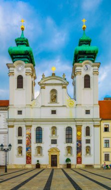 GYOR, HUNGARY MAY 20, 2016: People are walking in front of the Benedictine Loyolai Szent Ignac Church on szechenyi square in Gyor, Hungary