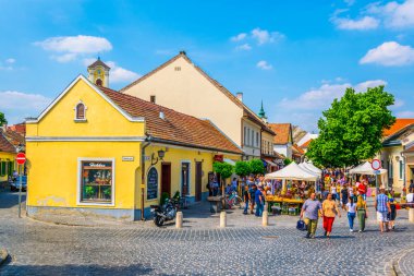 SZENTENDRE, HUNGARY 22 Mayıs 2016: Macaristan 'ın Szentendre kasabasında insanlar vızıldayan bir sokakta yürüyor