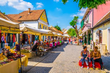 SZENTENDRE, HUNGARY 22 Mayıs 2016: Macaristan 'ın Szentendre kasabasında insanlar vızıldayan bir sokakta yürüyor