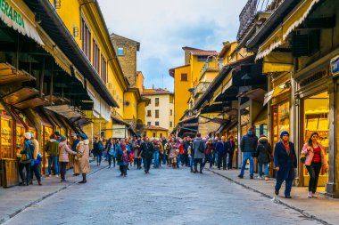 FLORENCE, ITALY, 15 Mart 2016: İnsanlar İtalya 'nın Floransa kentindeki Ponte vecchio köprüsündeki geniş dükkanlar arasında geziniyor